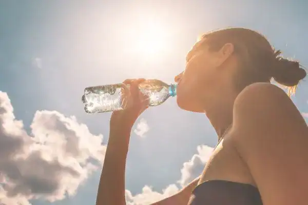 Hydration: The Secret Ingredient for a Toned Stomach and Enhanced Fitness 3 Image of woman drinking water to hydrate Bognor Regis after run.