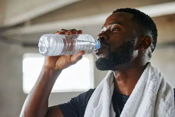 Hydration: The Secret Ingredient for a Toned Stomach and Enhanced Fitness 1 Image of man drinking water to improve hydration Bognor Regis after work out.